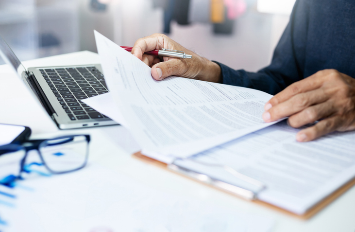 Sole trader reviewing business insurance documents on a laptop while managing tax-deductible insurance expenses for their Australian small business. Sole trader reviewing business insurance documents on a laptop while managing tax-deductible insurance expenses for their Australian small business.