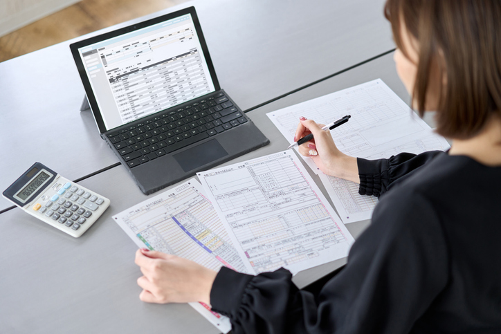 An Australian taxpayer reviewing tax documents on a laptop while checking their tax return status, with supporting paperwork and financial records nearby. An Australian taxpayer reviewing tax documents on a laptop while checking their tax return status, with supporting paperwork and financial records nearby.