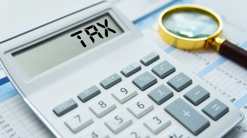 Calculator and financial records symbolising the Australian tax-free threshold, income tax brackets and how tax is calculated on earnings.