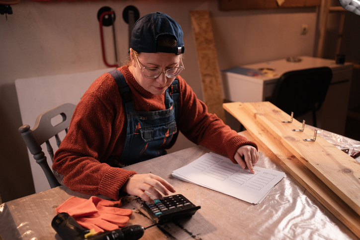Sole trader calculating business expenses and reviewing financial records for Australian tax planning and deductions.
