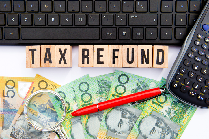 Tax refund in Australia with Australian banknotes, calculator and pen, representing ATO tax refunds, refund calculations, tax return lodgement and maximising your tax refund.
