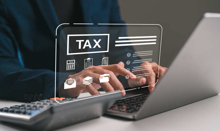 Person completing a tax return online using a laptop. Person completing a tax return online using a laptop.