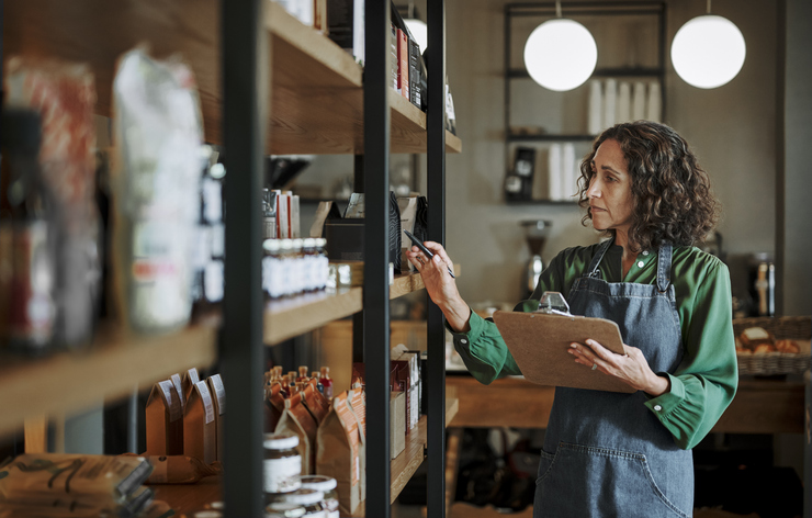 Small business owner managing trading stock and inventory records Small business owner managing trading stock and inventory records